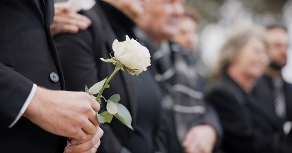  Man holding white rose at funeral 